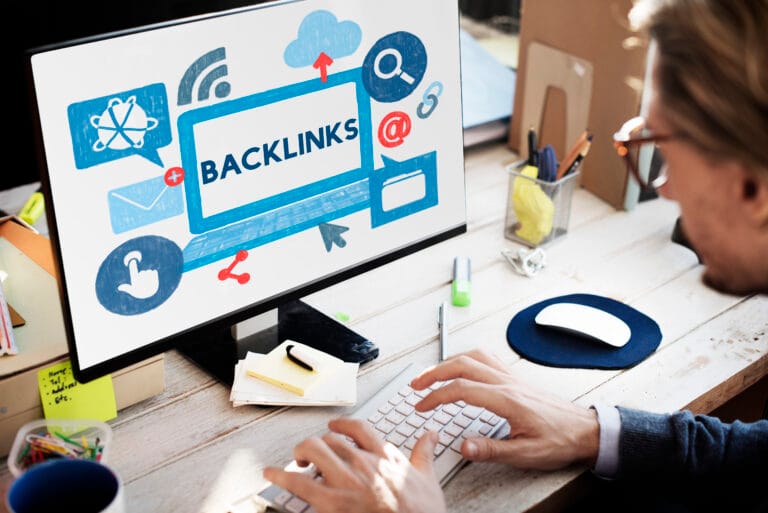 Backlink Hyperlink Networking Internet Online Technology Concept - NIHCF - NIHCF - NIHCF Person typing on a keyboard as a monitor displays a blue sketch with the word BACKLINKS, suggesting SEO work.